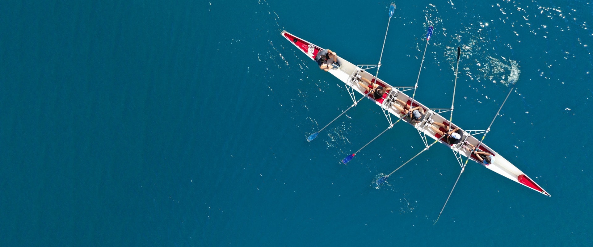 Aerial drone ultra wide photo of sport canoe with young team of athletes practising in deep blue open ocean sea