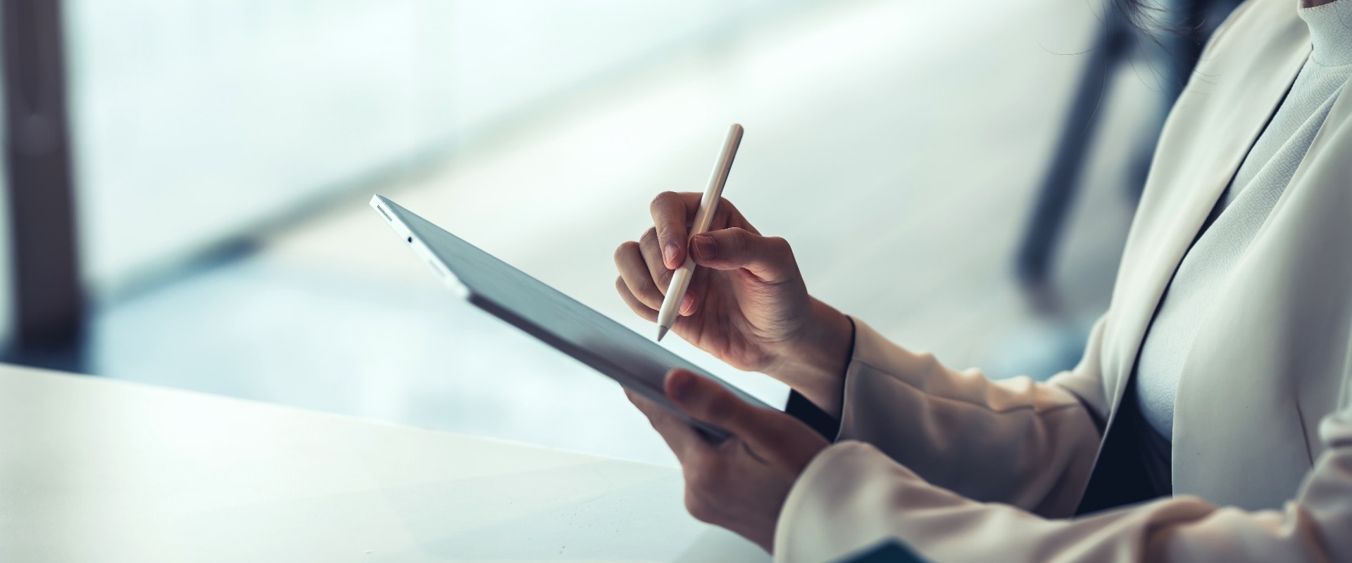 Close up of a businesswoman holding a pen working on a tablet at the office.